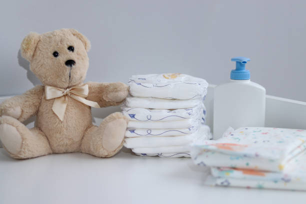 istock A stack of diapers, teddy bear and baby supplies on changing table 1995893378