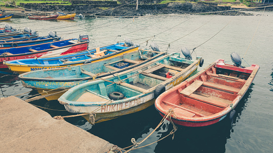 Colorful wooden fishing boats tied to ropes in the harbor of Hanga Roa on Rapa Nui, Easter Island