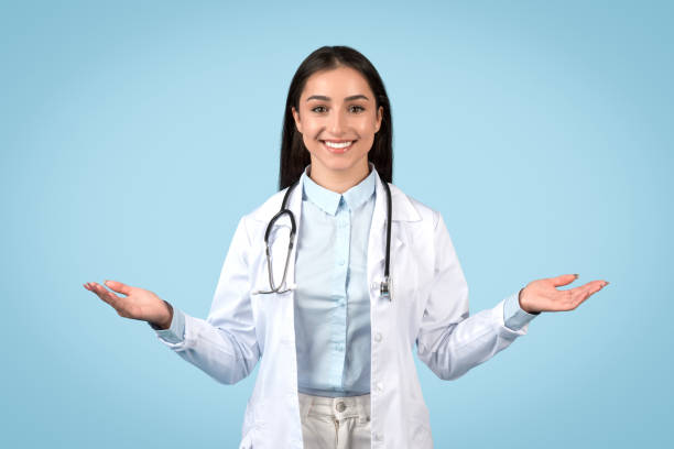 istock Balanced female doctor with open palms, blue backdrop 1995923169
