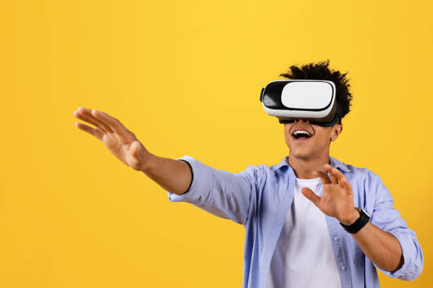 istock Excited black male student tries VR on yellow background 1995947333