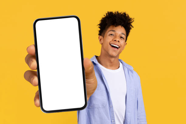istock Excited black teen guy showing smartphone screen, laughing joyfully 1995947341
