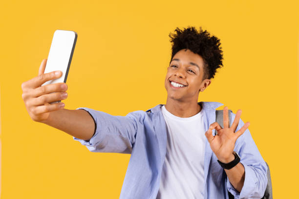 istock Cheerful teen black guy taking selfie with OK gesture 1995947872
