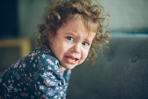 Close up portrait of crying little toddler girl