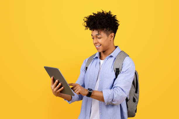 istock Happy black male student with tablet and backpack 1995948465