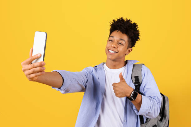 istock Happy black male student taking selfie with thumbs up 1995948477