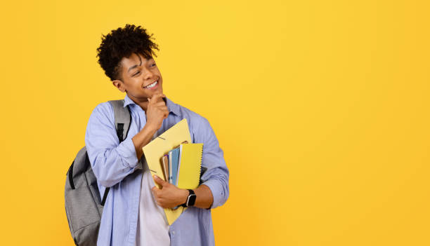 istock Thoughtful smiling black male student with books and backpack 1995948482