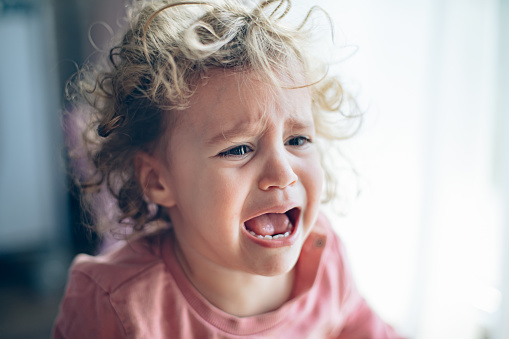 Close up portrait of crying little toddler girl