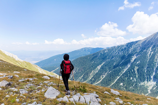 Mature  Woman with Backpack  Hiking  in the summer mountain . Rila ,Bulgaria