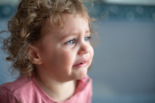 Close up portrait of crying little toddler girl