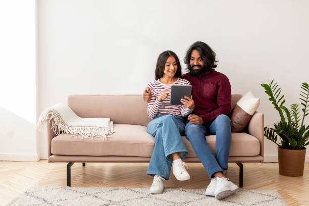istock Cheerful indian man and woman using digital tablet 1995963154