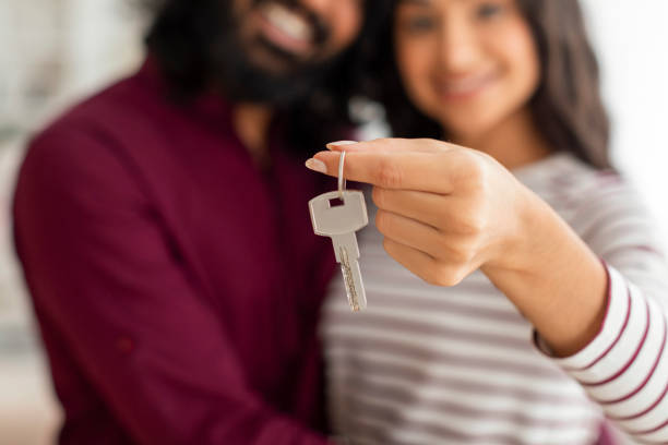 istock Key from apartment in married couple hands 1995963167