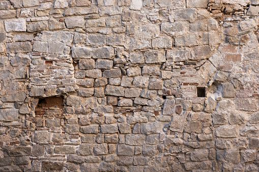 A blank stone wall revealing different time periods and material in Barcelona, Spain