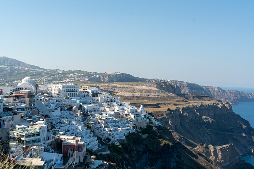 Oia town traditional white houses and churches with blue domes over the Caldera, Aegean sea