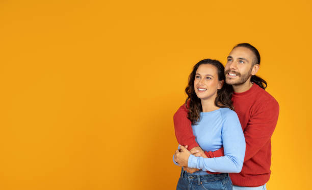 istock Beautiful young european couple hugging and looking at copy space 1995980290
