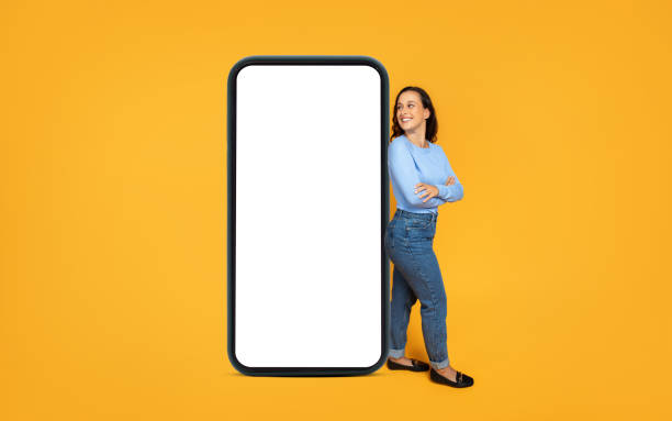 istock Curious millennial woman looking at big phone screen 1995980310