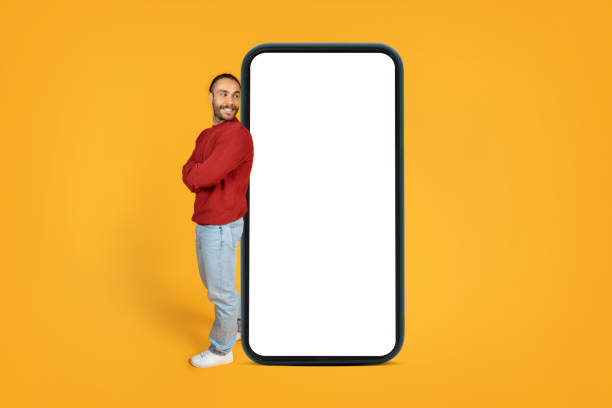 istock Curious millennial man looking at big phone screen 1995980312