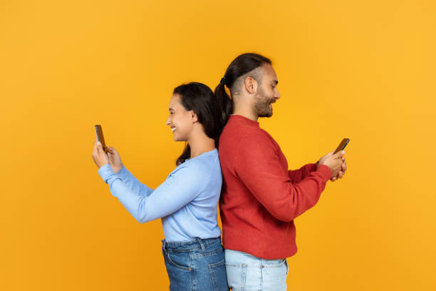 istock Cheerful millennial girlfriend and boyfriend using their smartphones 1995980854