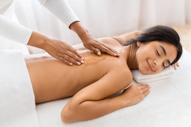 istock Therapist scrubbing client body with sea salt 1996004841
