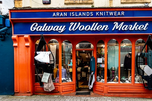 An inviting storefront of the Galway Woollen Market showcasing traditional Irish knitwear in Galway, Ireland,a variety of textile goods on display.