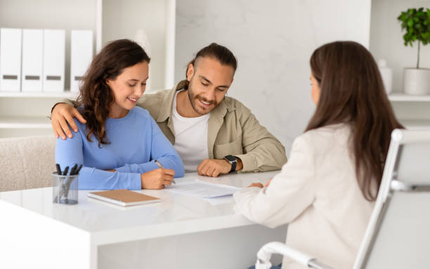 istock Professional adviser explaining house ownership and insurance details to spouses 1996025729