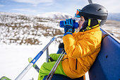 Boy on the ski lift with mountain background