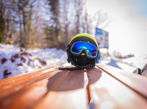 Ski helmet with ski goggles with mountain and snow in the background