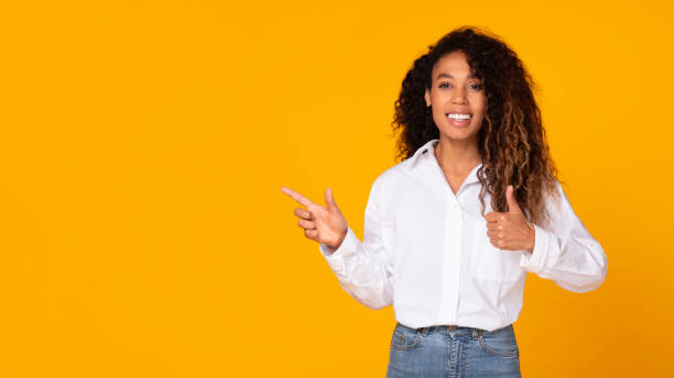 istock Excited African American Gesturing Thumbs Up Woman Pointing Aside, Studio 1996049968