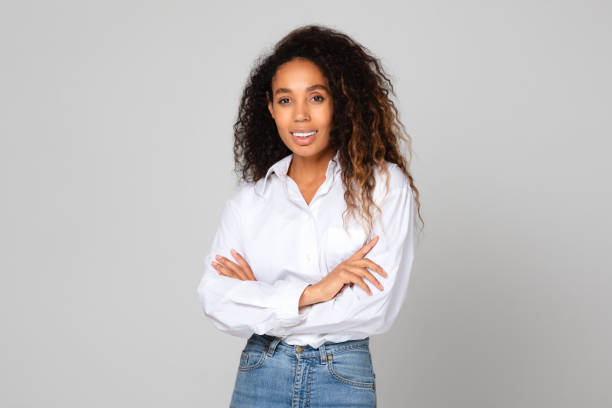 istock Black young lady crosses hands standing with confidence, gray backdrop 1996050536