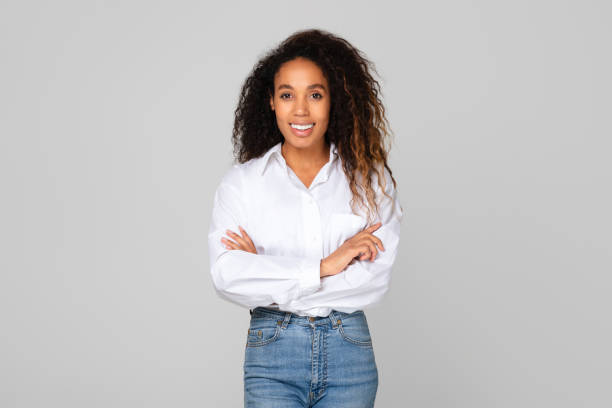 istock Happy black lady poses with confidence crossing hands, gray background 1996051102