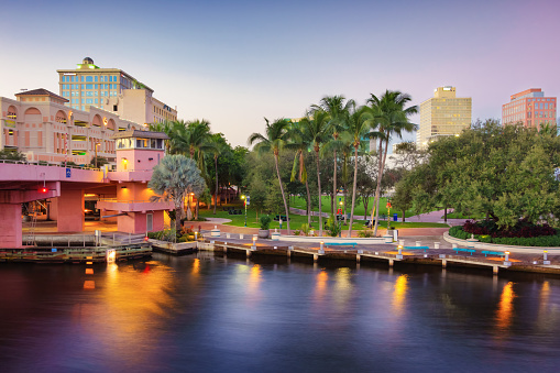 Riverwalk in downtown Fort Lauderdale, Florida, USA with Huizenga Plaza and Andrews Avenue Bridge over the New River at night.