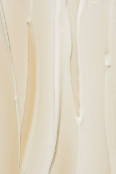 istock strokes of white cream on a beige background, macro texture 1996090980
