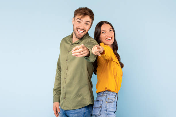 istock Cheerful couple pointing at camera, inviting and friendly 1996095105