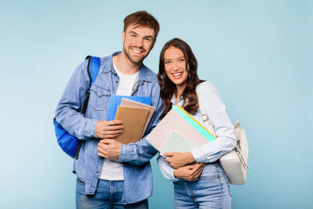 istock Cheerful student couple with books and backpacks ready for class 1996095114