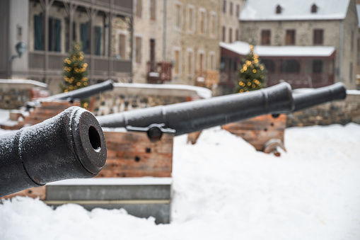 Old cannon surrounded by snow at Royal Battery in Quebec city during winter day