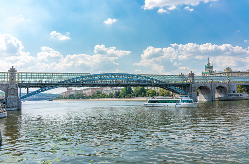 View of the Moscow river embakment, Pushkinsky bridge and cruise ships at sunset. Wide Moskva River, Pushkinsky bridge, Ministry of Defence, Groky Park, Frunzenskaya embankment,