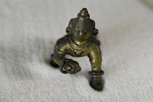 Crafted long, long ago in India, this small brass figure is the Baby Krishna with butter which he stole from his mother. It shows the wear of many children's fingers.  Lovely and enchanting.