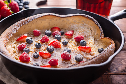 Cast Iron Skillet Dutch Baby with Strawberry, Blueberry, Raspberry and Powdered Sugar