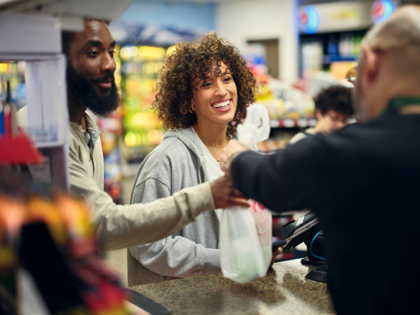 Young Couple Shopping in a Convenience Store A young couple shopping in a small convenience store. shaved black women stock pictures, royalty-free photos & images