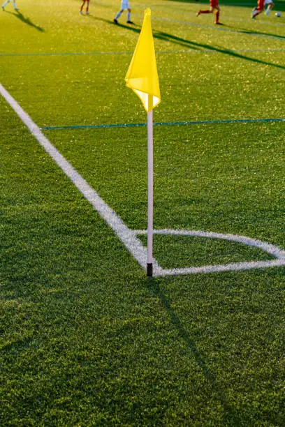 Castilla la Mancha, Spain. Close-up view of the corner flag on the soccer field with players in the background