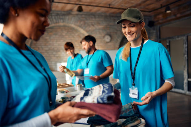 istock Happy volunteers packing donated clothes while working at humanitarian aid center. 1996174015