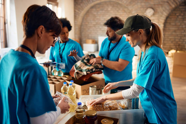 istock Diverse group of people sorting donated food for those in need while working at community center, 1996176052