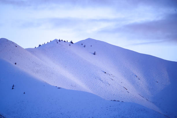 A view of a mountain range standing on top of a snowy peak