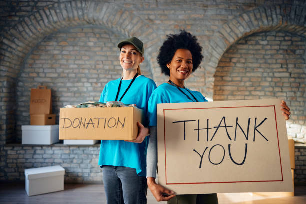 istock Happy women volunteering at charitable foundation and looking at camera. 1996180151