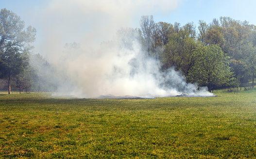 The farmer in Missouri has set old hay and straw on fire but all that can be seen is a thick cloud of smoke.