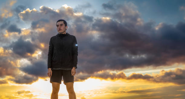 istock Serious man wearing sportswear, sky in the background representing effort, with space for text 1996242079