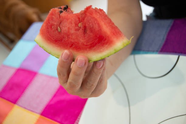 istock Hands Cuting and Holding a Delicious Watermelon Ready to Eat 1996243672