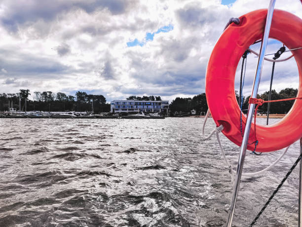 Lifebuoy from a sailboat on a lake with a marina in the background