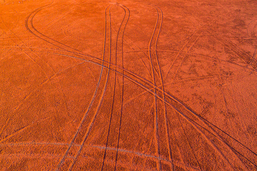 Abstract aerial view of dry red dirt desert area in the middle of the Australian outback with tyre tracks