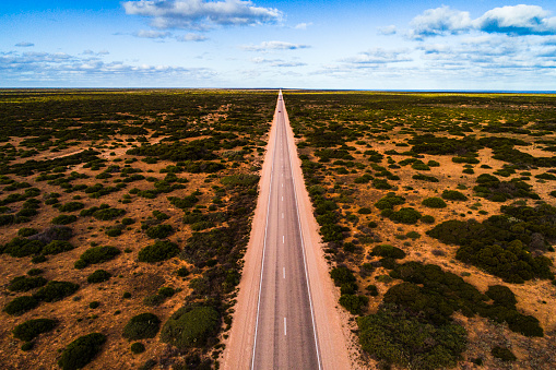Aerial view of a long straight road in Australia across the outback. Captured while crossing the Nullarbor.