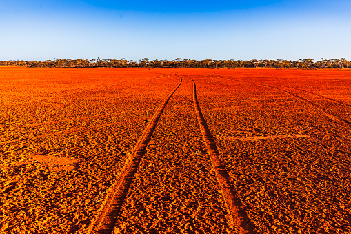 Dry red dirt desert area in the middle of the Australian outback with tyre tracks